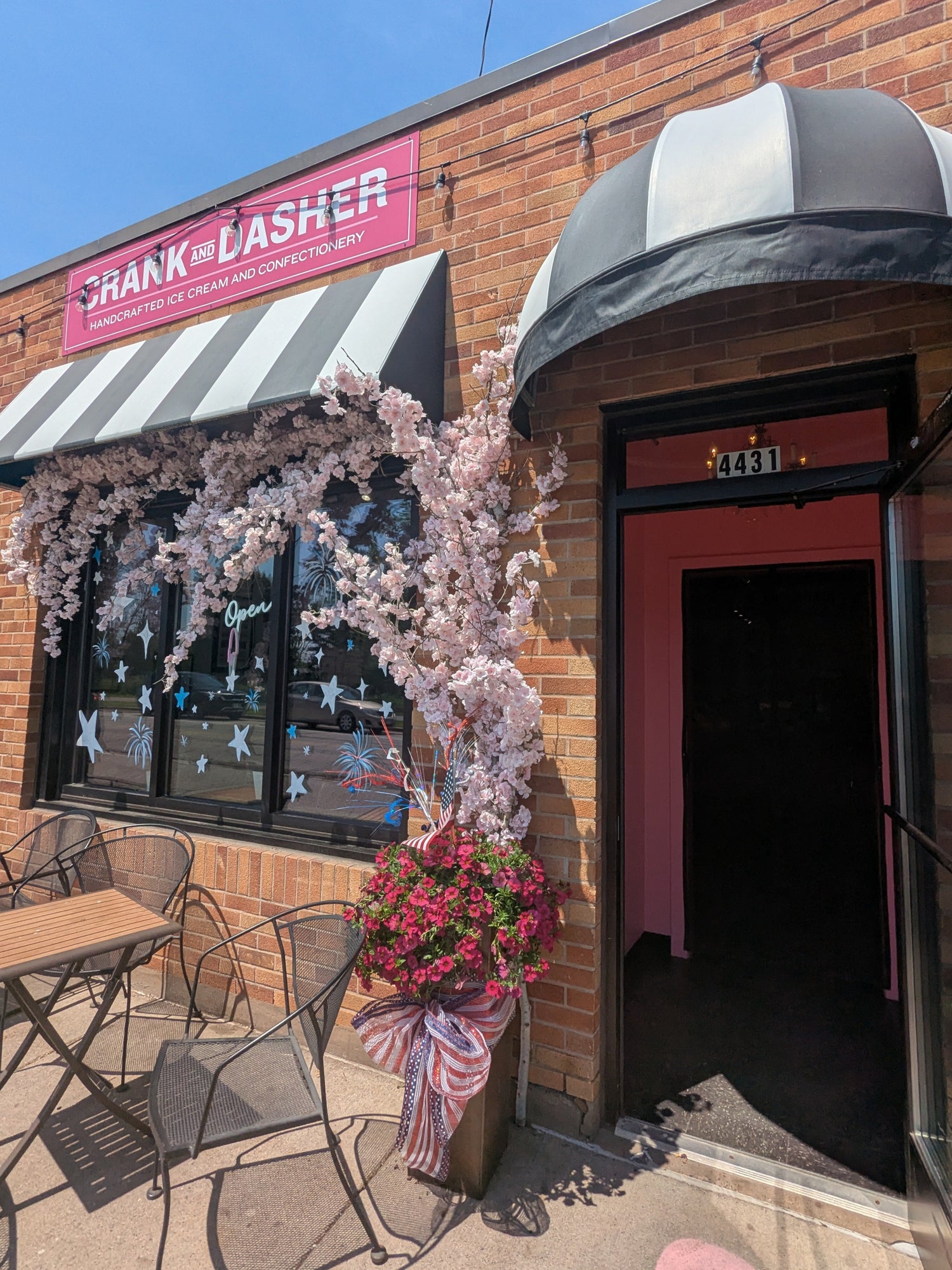 Brick building with 'Chank & Dasher' sign, outdoor seating area, and cherry blossom decorations.