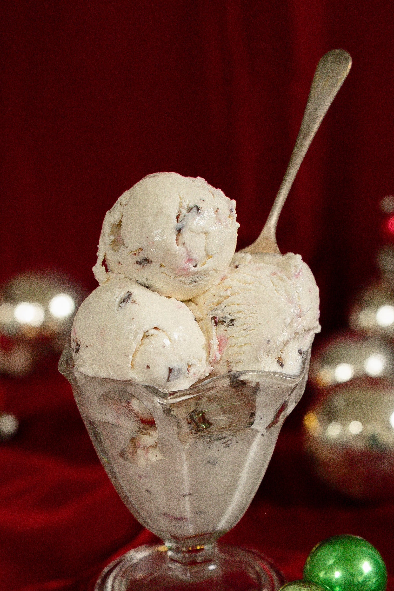Ice cream sundae with Christmas ornaments on a red background